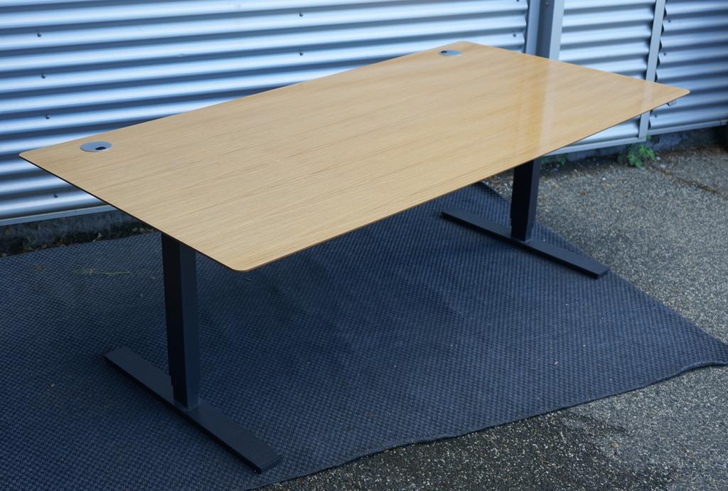 Scanoffice hæve-sænkebord i egetræ 200x100 cm set fra skrå vinkel – stort direktørbord med mørkt stel og kabelbakke.